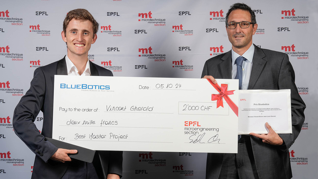 Pierre Lamon, vice-président de la recherche chez BlueBotics, remet le prix annuel BlueBotics à Vincent Gherold.